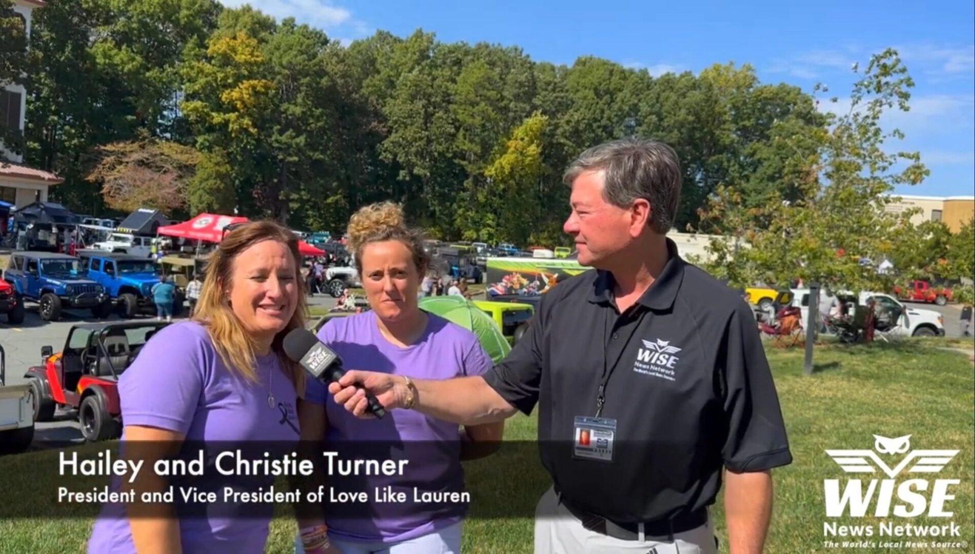 Three people are outdoors; a man holding a microphone interviews two women. Text on the image reads, "Hailey and Christie Turner, President and Vice President of Love Like Lauren." WISE News Network.