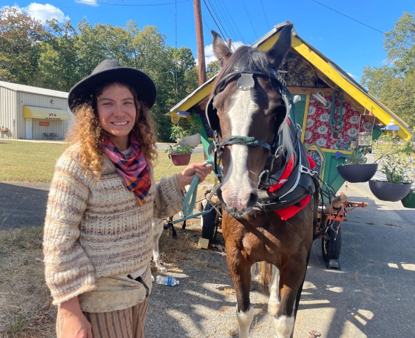 A woman standing next to a horse on the street.