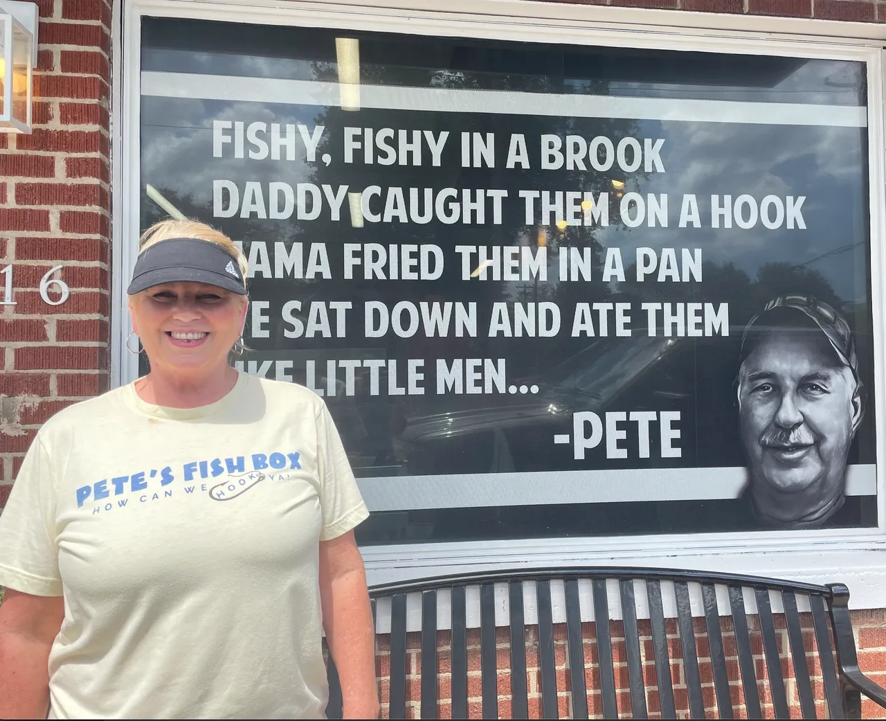 A woman standing in front of a sign.