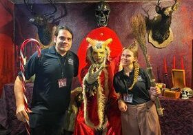 A man and two women posing with an animal costume.