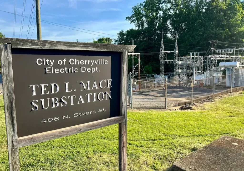 A sign for Ted L. Mace Substation, part of the City of Cherryville Electric Department, is in the foreground with the substation facility visible behind it.