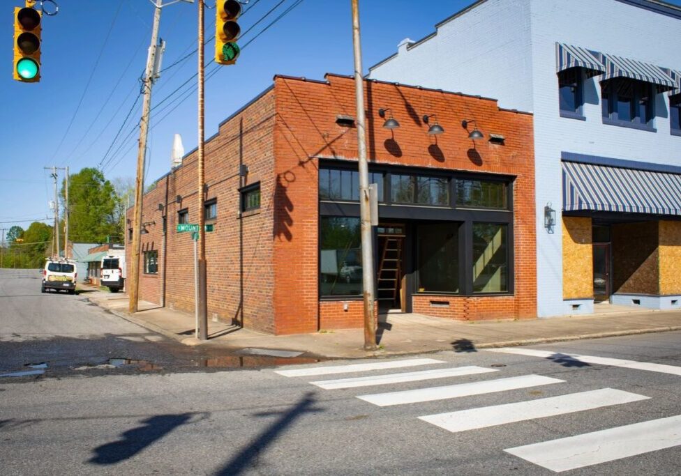 A brick building on the corner of an intersection.