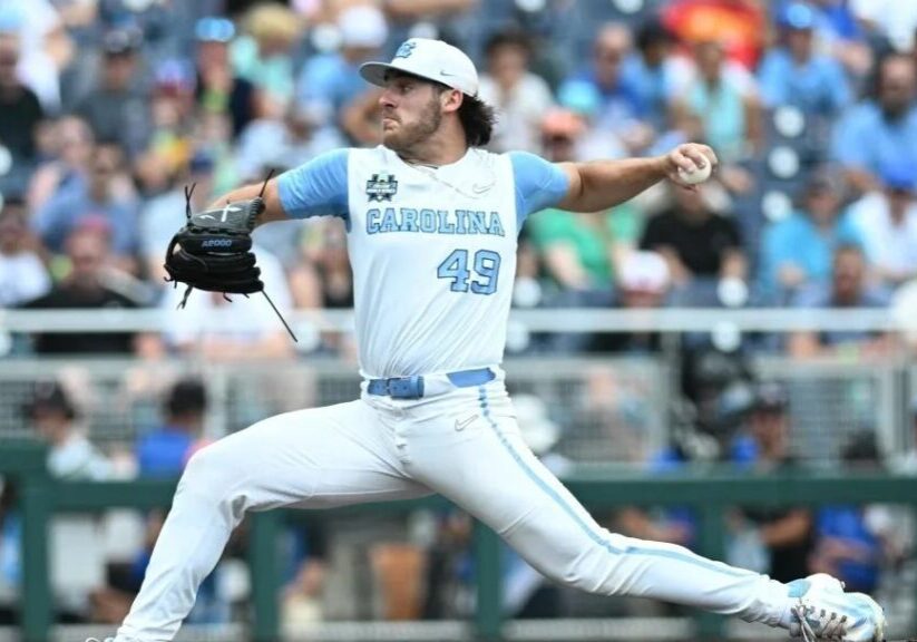 A baseball player in a light blue and white uniform with the number 49 pitches during a game, with an audience visible in the background.