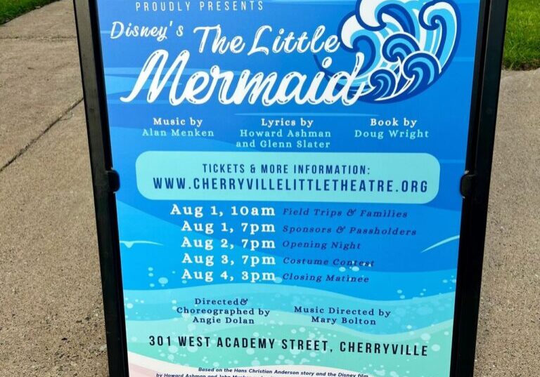 A sign promoting "Disney's The Little Mermaid" by Cherryville Little Theatre with showtimes in August 2023, held at 301 West Academy Street, Cherryville.