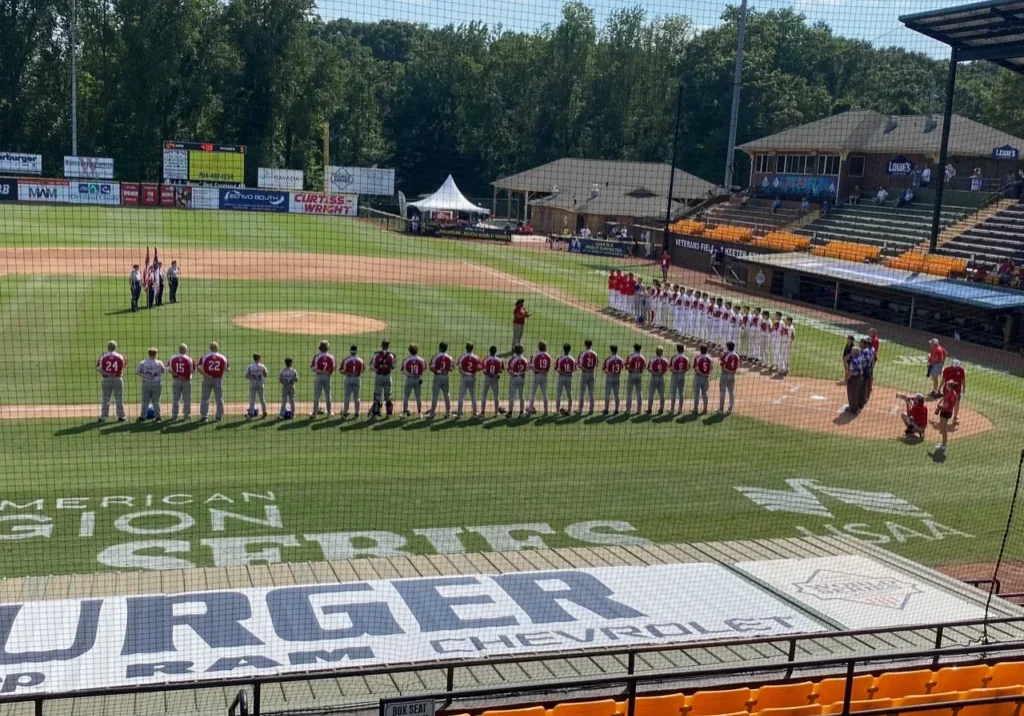 A baseball game with players lined up for the national anthem.